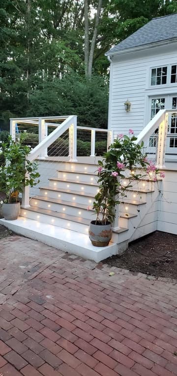 Deck stairs with built-in step lights and white railings