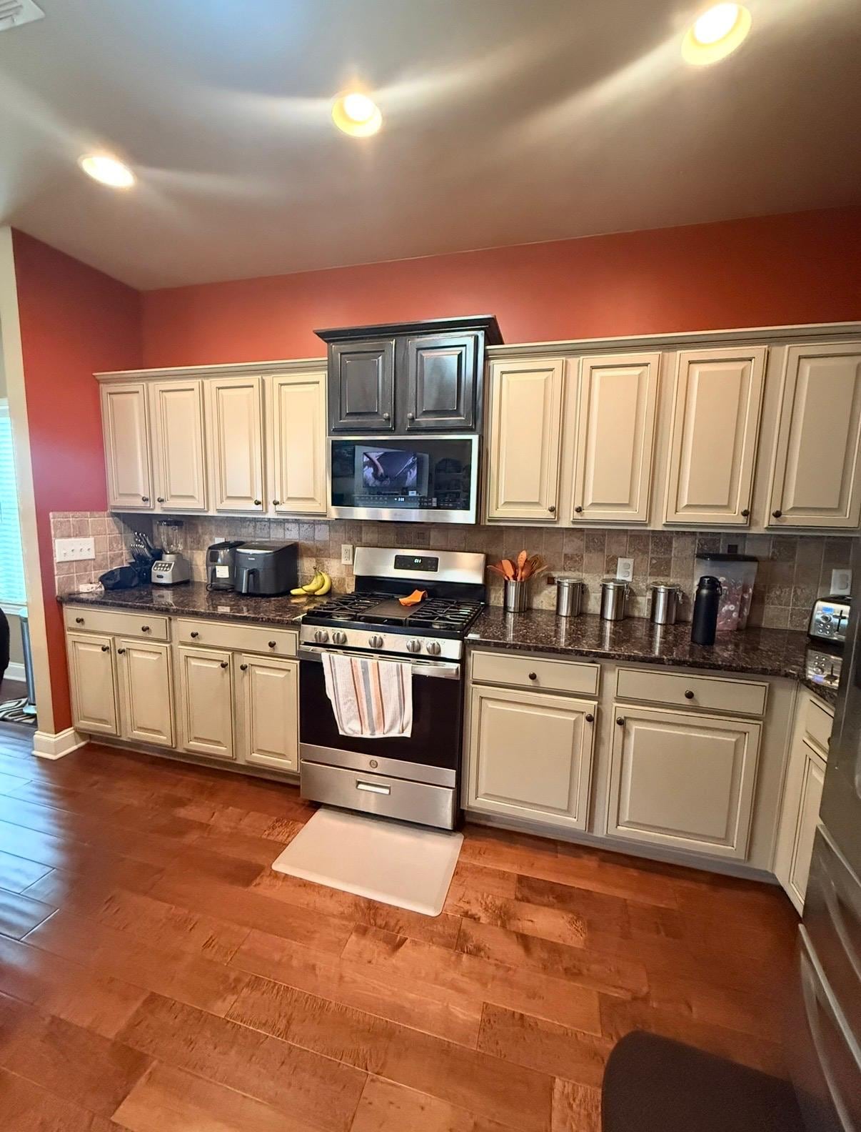 Kitchen before remodeling: cream cabinets, dark granite counters and orange walls