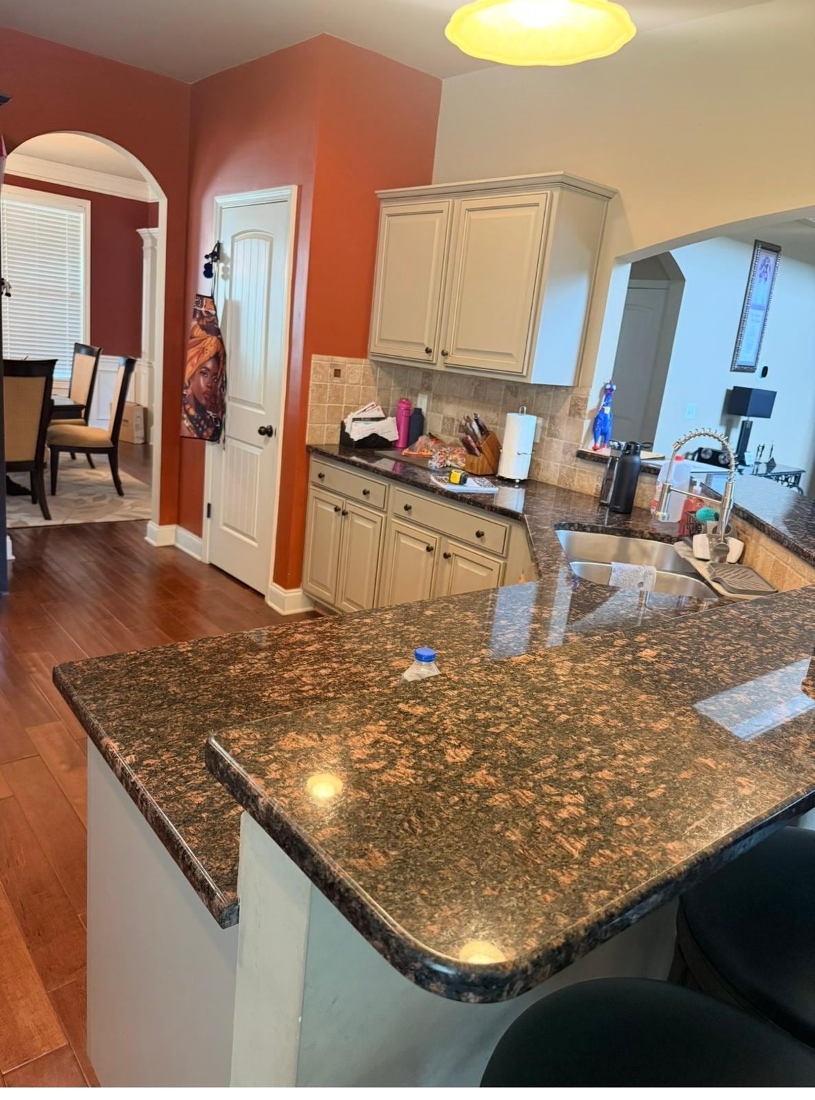 Kitchen peninsula before remodeling, with dark granite and cream cabinets