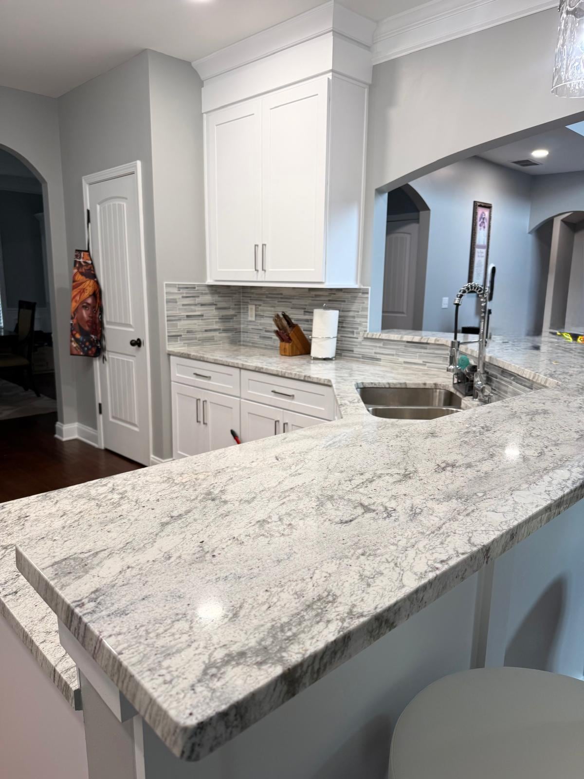 Remodeled kitchen with white cabinets, granite countertops and a sink