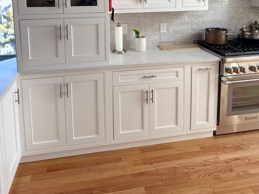 Finished kitchen remodel with white cabinets and oak floor