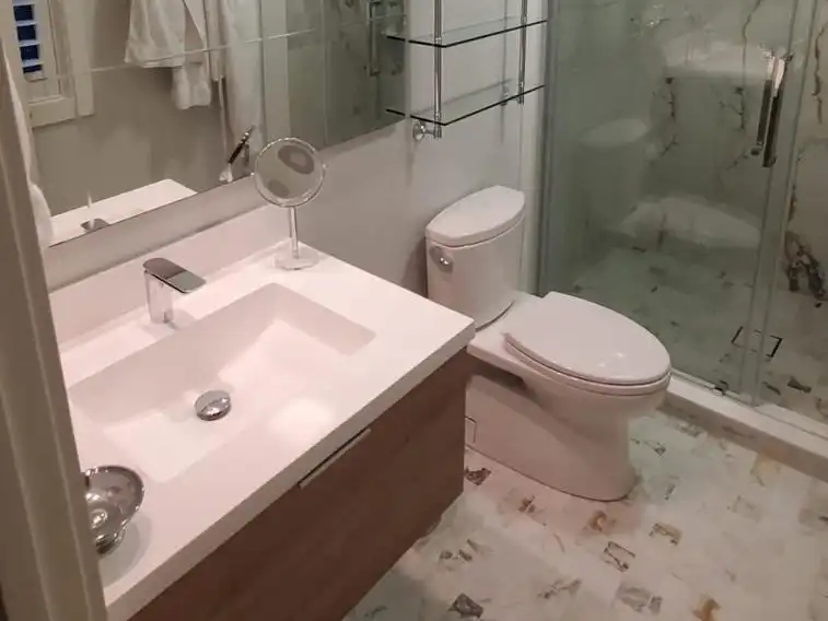 Bathroom with a floating wood vanity, marble-look floor tile and a sliding glass shower